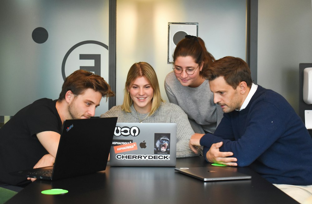 Team collaborating around a laptop
